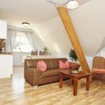 Wohnzimmer mit Sofa, Couchtisch und Sessel unter Dachschrägen.