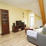 Wohnzimmer mit Sofa, Fernseher und Holzmöbeln.