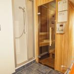 Dusche und Sauna mit orangefarbenem Liegestuhl