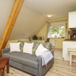 Wohnzimmer mit Sofa, Couchtisch und Blick in die Küche