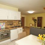 Küche mit Essbereich und Wohnzimmer mit Sofa und Fernseher.