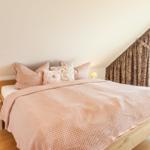 Schlafzimmer mit Bett, Nachttisch und Fenster