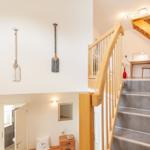 Haus mit Holztreppe, Wandbehang und Arbeitsplatz im Obergeschoss.