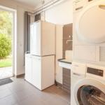 Wohnung mit Waschmaschine und Trockner, Kühlschrank und Blick auf Garten.