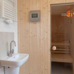 Dusche mit Sauna, Waschbecken und Heizung.