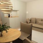 Wohnbereich mit Sofa, Tisch und moderner Beleuchtung.