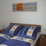 Schlafzimmer mit Bett, Nachttischen und Wandbild