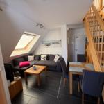 Wohn- und Essbereich mit Holztreppe und Dachschrägen.