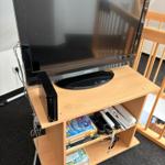 TV auf Holzregal mit Wii-Konsole und Spielen