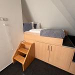 Ein Bett auf Hochbett mit Stufen und Schubladen