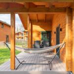 Terrasse mit Hängemattenaufstellplatz und Sitzgruppe unter Holzüberdachung.