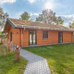 Holzhaus mit Grasdach, Garten und Steintreppe.