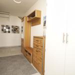 Eingangsbereich mit Holzmöbeln, Teppich und Wandbildern.