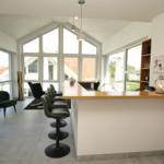 Barbereich mit grünen Barhockern und großen Fenstern zur Aussicht.