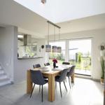 Esszimmer mit Holztisch, Stühlen und Blick auf die Terrasse.