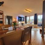 Essbereich mit Tisch und Stühlen, Fernseher und Kamin im Hintergrund.