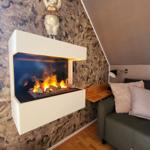 Wohnbereich mit Kamin und Sofa an steilem Dach