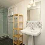 Badezimmer mit Dusche, Waschbecken und Handtuchhalter.