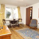 Ein Raum mit Holzboden, einem blauen Teppich und einem Gemälde an der Wand.