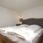 Ein Schlafzimmer mit einem Bett, zwei Nachttischen und Bildern an den Wänden.