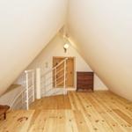 Dachgeschoss mit Holzboden, Treppe und Kleiderschrank.