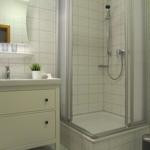 Badezimmer mit Dusche, Waschbecken und Toilette.