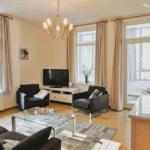 Wohnzimmer mit zwei Sesseln, Glas-Tisch und Fernseher.