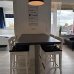 Essbereich mit Tisch und Stühlen. Wohnbereich mit Sofa und Balkonansicht.