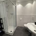 Badezimmer mit Dusche, Toilette und Waschbecken.