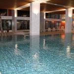 Großes Hallenbad mit Liegestühlen und Holzdecke.