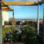 Terrasse mit Pergola, Pflanzen und Meerblick.