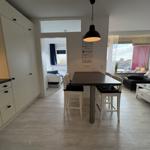 Essbereich mit Tisch und Stühlen. Küche, Wohnzimmer und Schlafzimmer sichtbar.