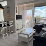 Wohn- und Essbereich mit Balkonblick. Schwarz-weiße Einrichtung.