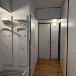 Flur mit Schränken, Garderoben und Holzboden.