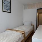 Ein Schlafzimmer mit zwei Einzelbetten, einem Schreibtisch und einer Wanddekoration.