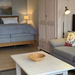 Schlafzimmer mit Bett, Sofa und Kleiderschrank. Tisch mit Schale davor.