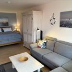 Ein Schlafzimmer mit Sofa, Kleiderschrank und Wandbildern.