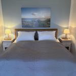 Doppelbett mit zwei Nachttischen und Wandbild im Schlafzimmer