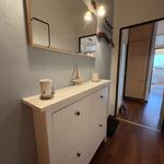 Eingangsbereich mit Schrank, Spiegel und Tür zum Schlafzimmer.