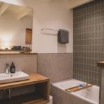 Badezimmer mit Badewanne, Waschbecken und Spiegel