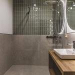Badezimmer mit Dusche, Waschbecken und Spiegel