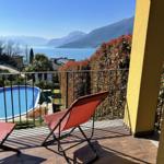 Terrace with loungers and view of pool and lake