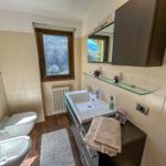 Bathroom with sink, toilet, and bathtub. Window with mountain view.