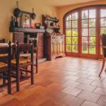 Dining room with wooden furniture, brick fireplace, and garden view.