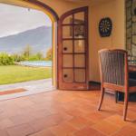 Entrance area with view of pool and mountains. Table, chair, and dartboard.
