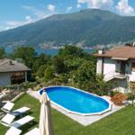 Pool with loungers and view of lake and mountains.