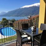 Terrace with table and chairs, view of pool and mountain lake.