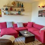 Living room with red sofa, wooden shelves, and coffee table.