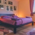 Schlafzimmer mit Bett, Bildern an der Wand und Fenster mit Blick.