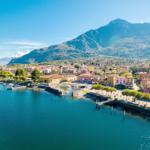 Hafenstadt mit Booten und Bergen im Hintergrund.